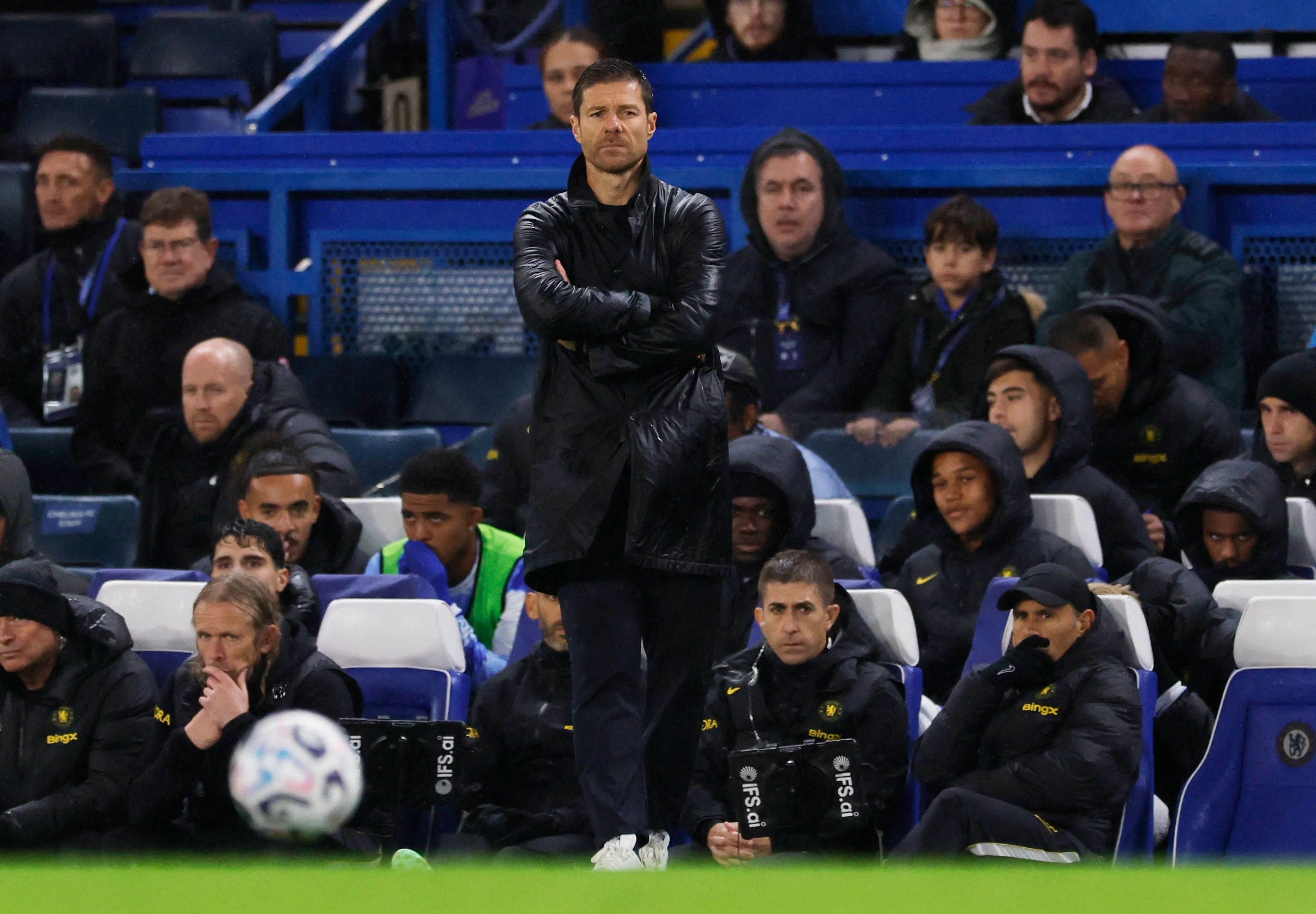 Chelsea manager Xabi Alonso watches on in the rain