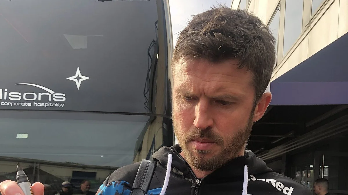 Michael Carrick in a black Middlesbrough training top, signing autographs outside a team coach
